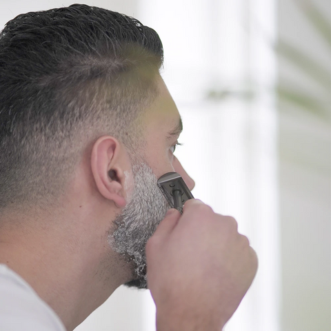 Man scheert zijn gezichtshaar met de zwarte safety razor